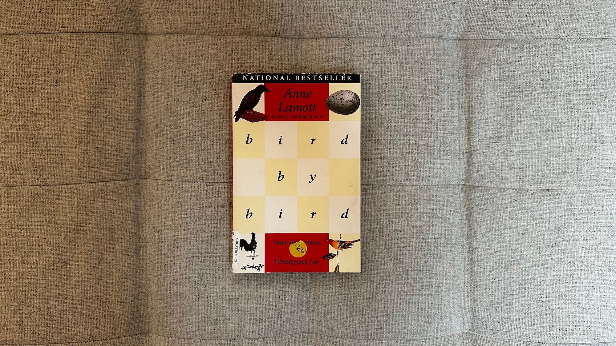 Book "bird by bird" by Anne Lamott laying on my couch.