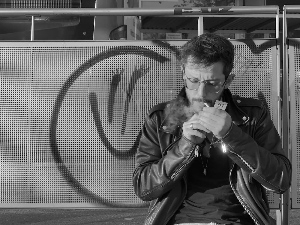Pat smoking an herbal cigarette that looks like a real cigarette.